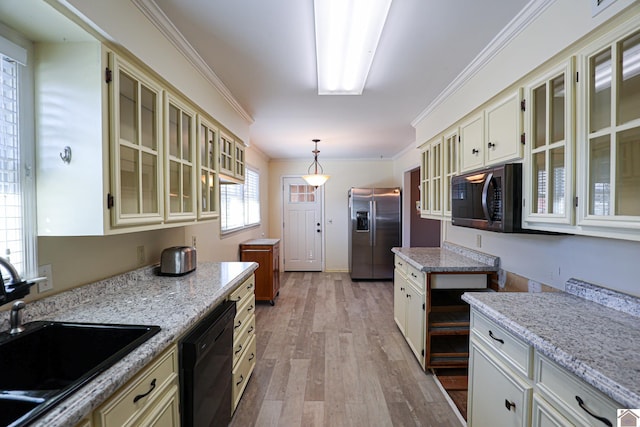 kitchen featuring a sink, ornamental molding, light wood-type flooring, black appliances, and glass insert cabinets