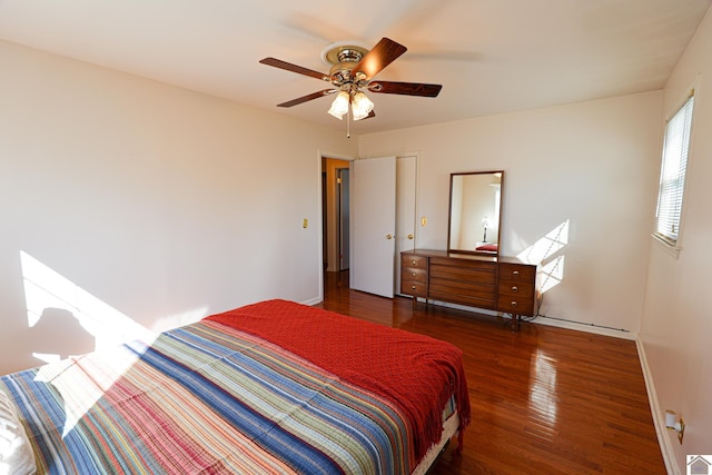 bedroom with ceiling fan, wood finished floors, and baseboards