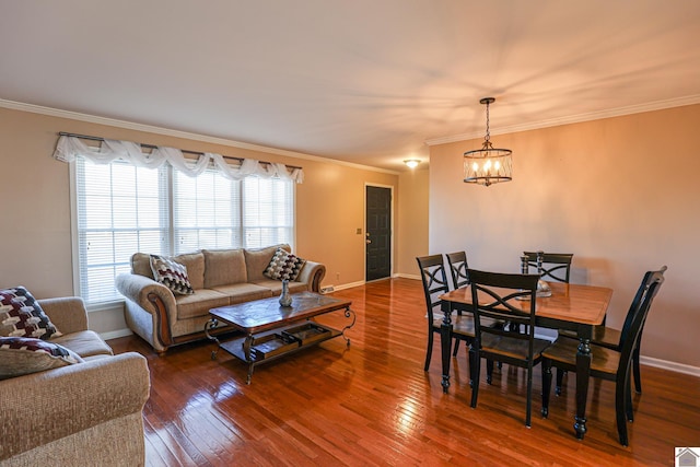 living room with ornamental molding, an inviting chandelier, baseboards, and hardwood / wood-style flooring