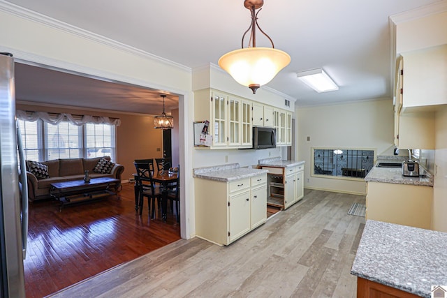 kitchen with glass insert cabinets, light stone counters, freestanding refrigerator, crown molding, and light wood-type flooring