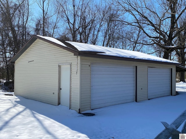 snow covered garage featuring a garage