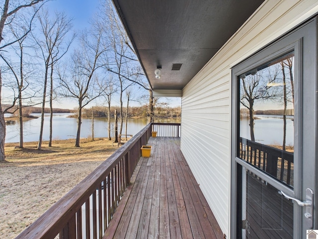 wooden deck featuring a water view and visible vents