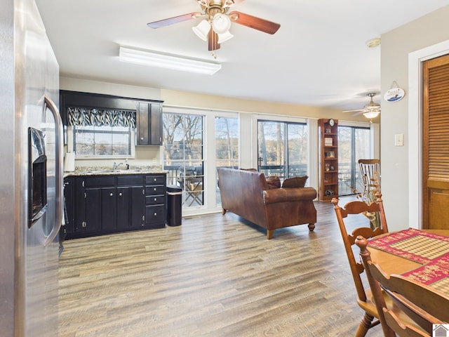 living room with a ceiling fan and light wood finished floors