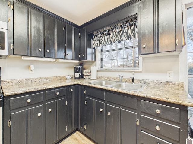 kitchen featuring light wood-type flooring, light countertops, and a sink