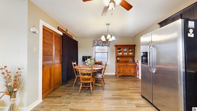 dining area featuring light wood-style floors, baseboards, and ceiling fan with notable chandelier