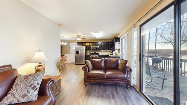 living area featuring light wood-style flooring and a ceiling fan