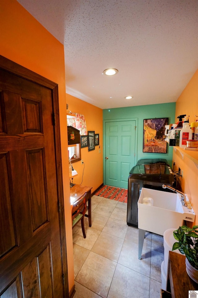 bathroom with a textured ceiling, a sink, tile patterned flooring, and recessed lighting