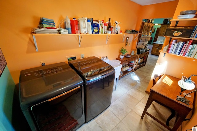 laundry area with light tile patterned floors and washing machine and dryer