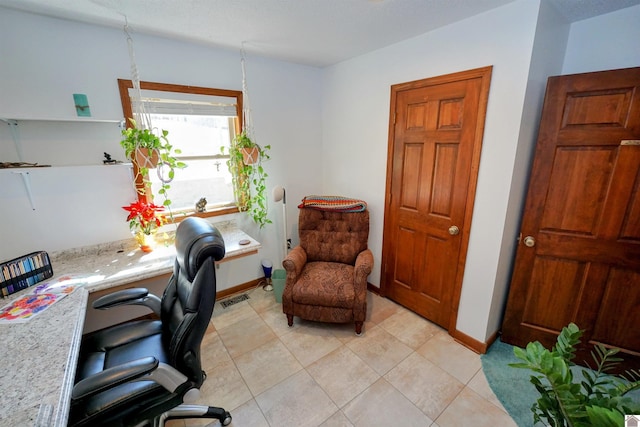 office featuring light tile patterned flooring, visible vents, and baseboards