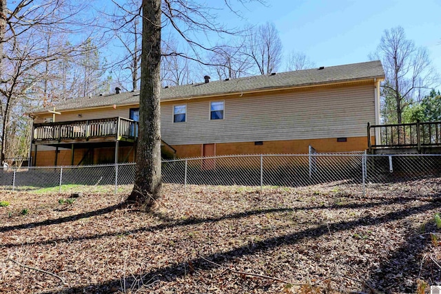 back of house featuring crawl space, a wooden deck, and a fenced backyard