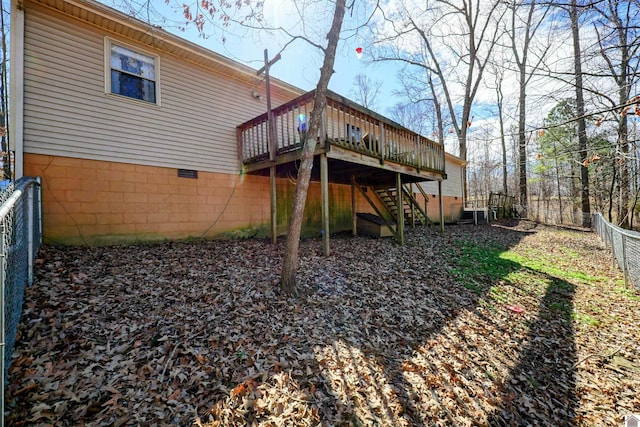 rear view of house featuring a fenced backyard, a wooden deck, and stairs