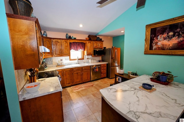 kitchen with brown cabinetry, vaulted ceiling, extractor fan, stainless steel appliances, and a sink