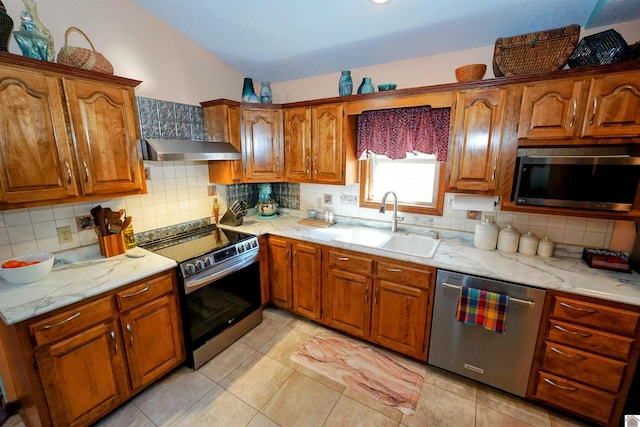 kitchen featuring a sink, stainless steel appliances, backsplash, and exhaust hood