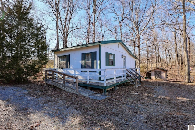 view of front of house with an outbuilding, a wooden deck, and a storage shed