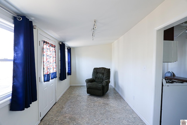 living area with track lighting and baseboards