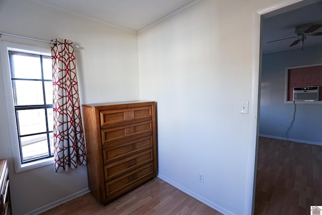 unfurnished bedroom with multiple windows, baseboards, and wood finished floors