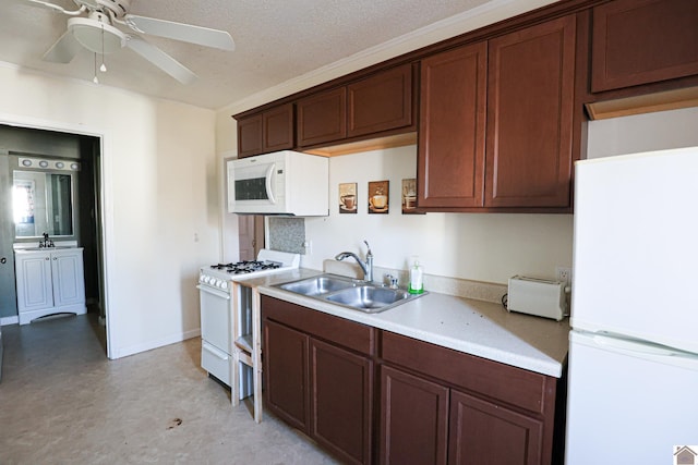 kitchen featuring a textured ceiling, light countertops, white appliances, and a sink