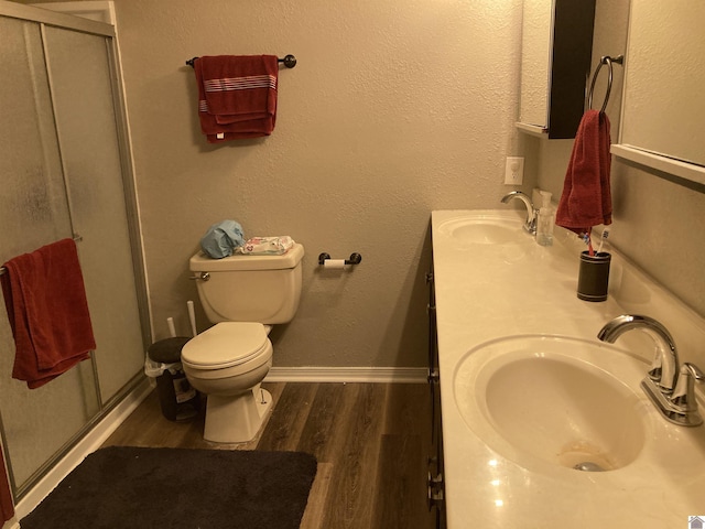 full bath featuring double vanity, wood finished floors, a stall shower, and a sink