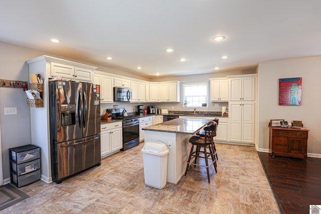 3929 Griggstown Rd, Calvert City, KY 42029 - kitchen with stainless steel microwave, black range with gas stovetop, a kitchen island, fridge with ice dispenser, and dark stone counters