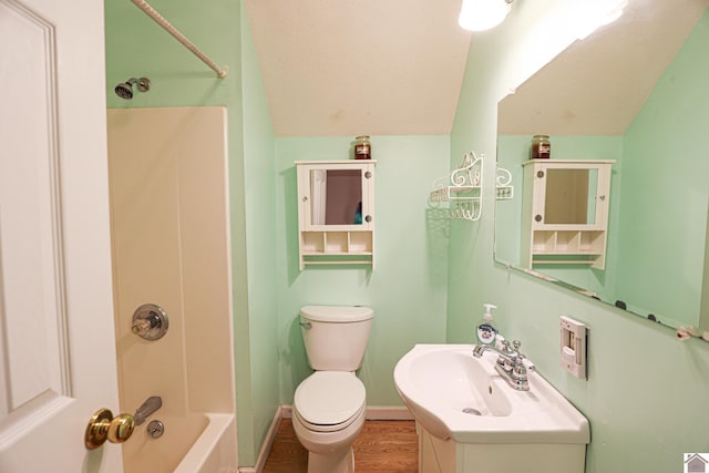 3929 Griggstown Rd, Calvert City, KY 42029 - bathroom with baseboards, toilet, wood finished floors, vaulted ceiling, and shower / washtub combination