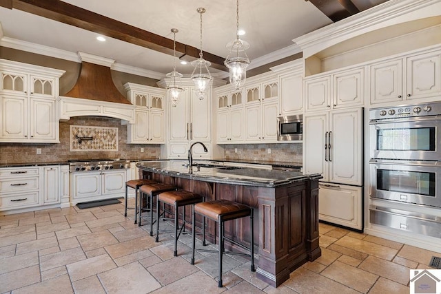 kitchen featuring stone tile floors, custom range hood, a breakfast bar area, built in appliances, and a warming drawer