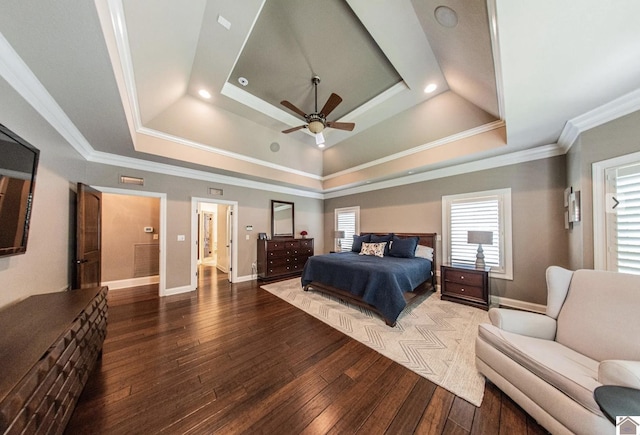 bedroom with ornamental molding, a tray ceiling, and hardwood / wood-style flooring