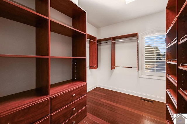 spacious closet featuring dark wood finished floors and visible vents