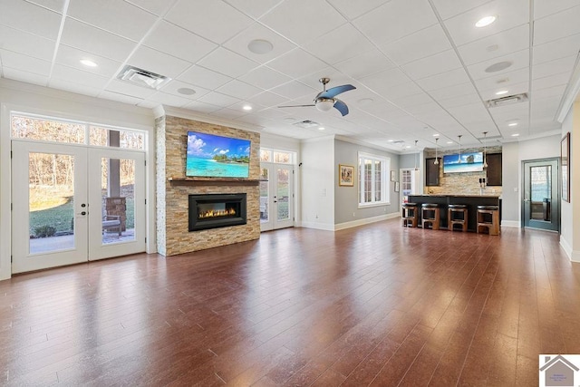 unfurnished living room with ornamental molding, french doors, dark wood-type flooring, and visible vents