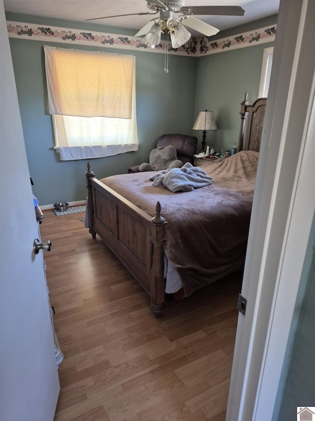 bedroom with baseboards, a ceiling fan, and wood finished floors