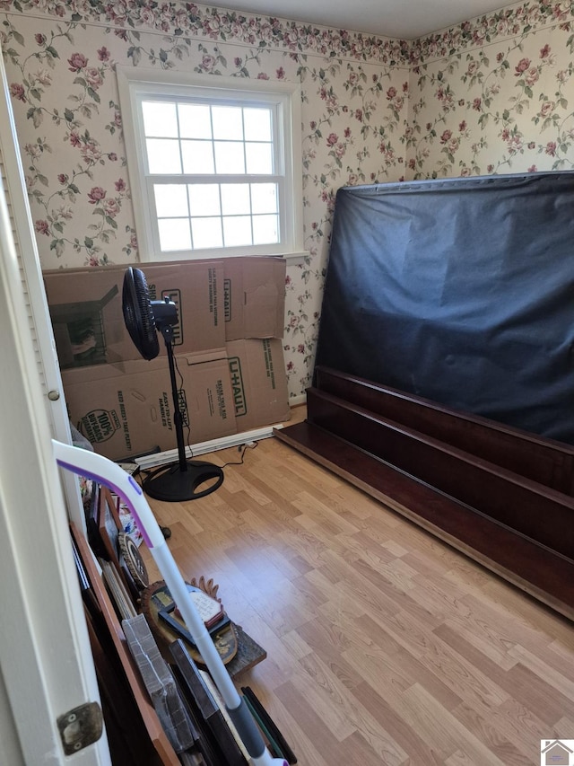 unfurnished bedroom featuring wallpapered walls and wood finished floors