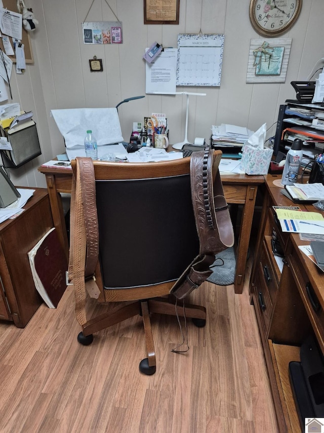 office area with a decorative wall and light wood-style floors