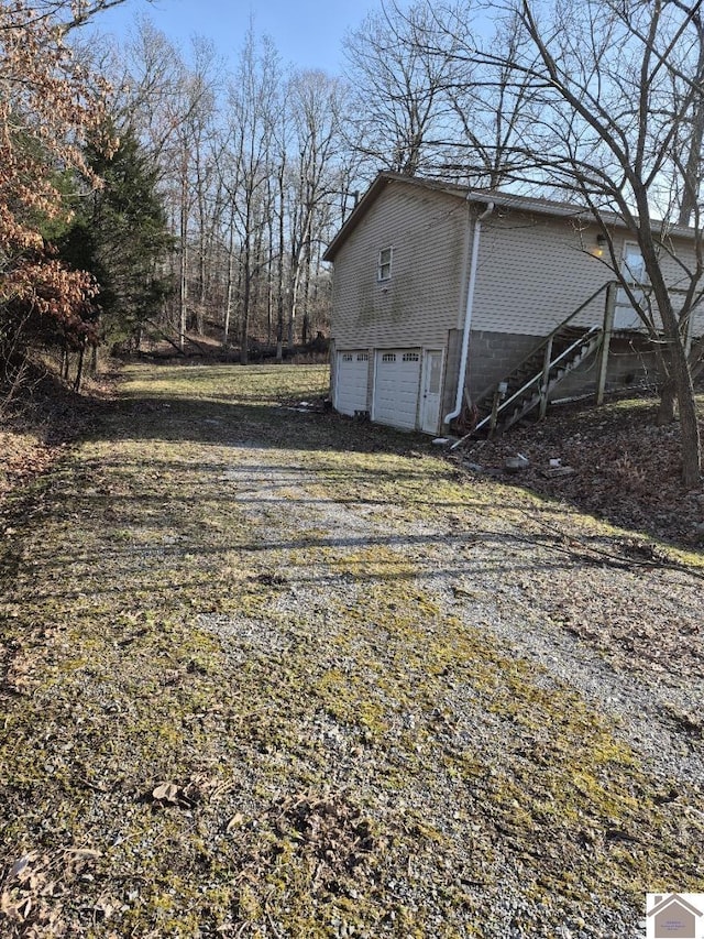 exterior space with a garage and gravel driveway