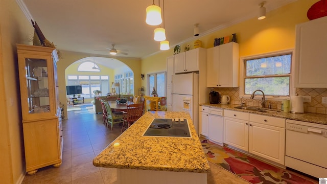 kitchen with white appliances, white cabinetry, a sink, and backsplash