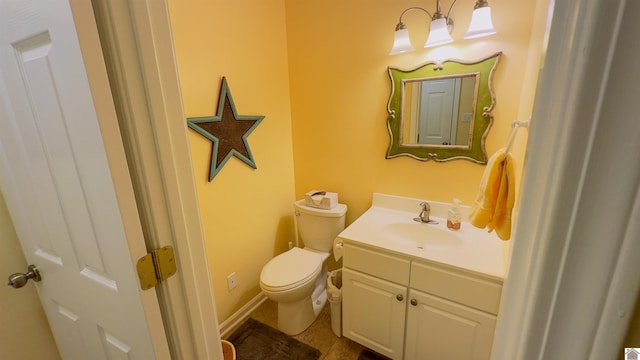 half bathroom with toilet, baseboards, and vanity