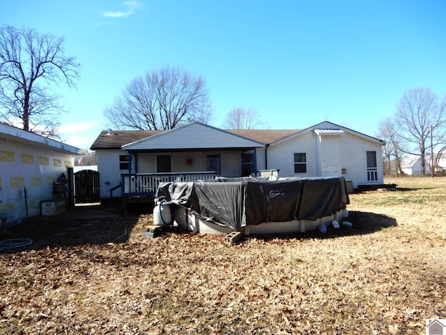 back of property featuring a pool and a gate