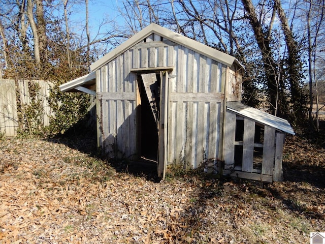 view of outbuilding featuring an outdoor structure and fence