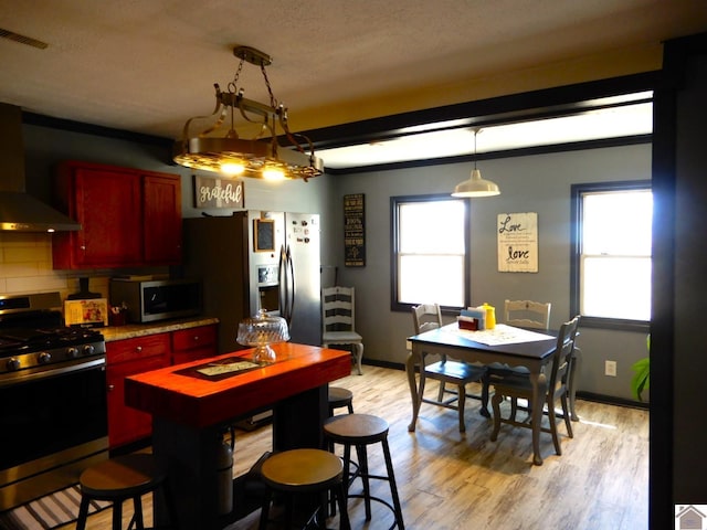 kitchen with dark brown cabinets, appliances with stainless steel finishes, plenty of natural light, and visible vents