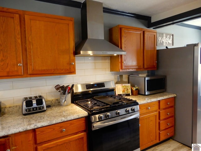 kitchen with wall chimney exhaust hood, brown cabinets, and stainless steel appliances