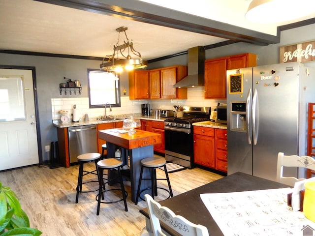 kitchen with stainless steel appliances, light wood-type flooring, backsplash, and wall chimney range hood