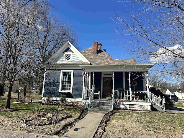 victorian home featuring a chimney and a porch