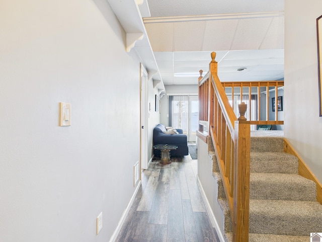 corridor with visible vents, stairs, baseboards, and wood finished floors