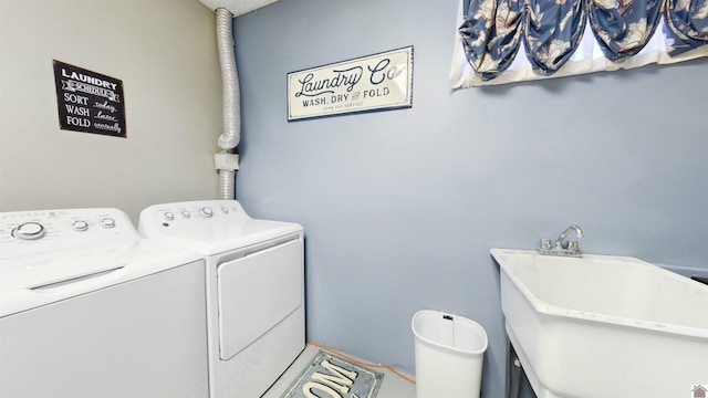 washroom featuring laundry area, a sink, and washing machine and clothes dryer