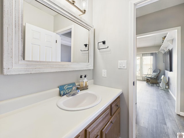 bathroom featuring vanity, baseboards, and wood finished floors