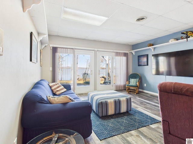 living area with a wealth of natural light, visible vents, and a paneled ceiling