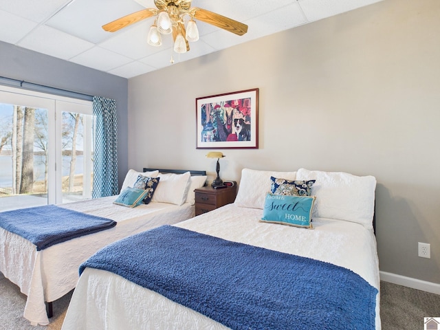 bedroom featuring carpet floors, a paneled ceiling, ceiling fan, access to outside, and baseboards