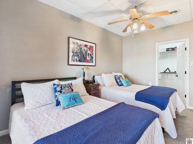 bedroom with visible vents, a ceiling fan, carpet flooring, a drop ceiling, and baseboards