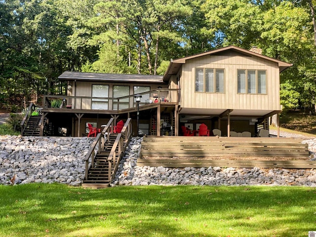 rear view of house with a lawn, a deck, and stairs