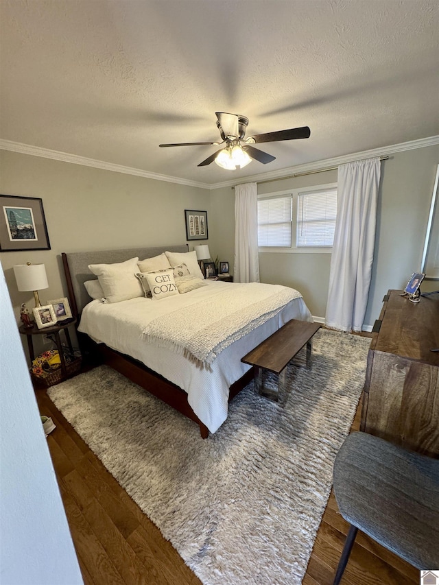 bedroom featuring ceiling fan, crown molding, a textured ceiling, and wood finished floors