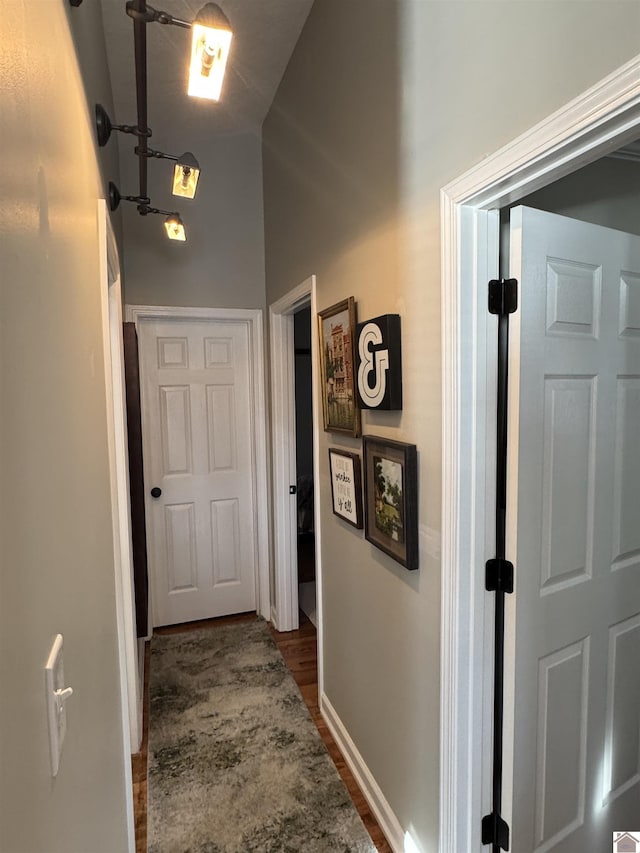 hallway with baseboards and dark wood finished floors