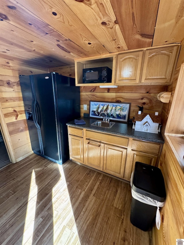 kitchen featuring wood ceiling, dark wood-style flooring, wood walls, black appliances, and a sink